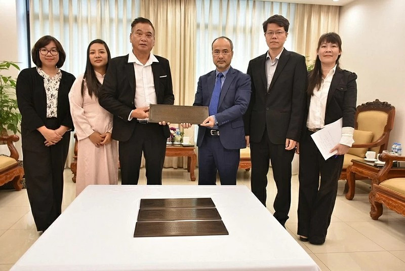 Председатель Государственного комитета по делам вьетнамцев, проживающих за границей, Нгуен Чунг Киен вручает бронзовую мемориальную доску представителю сообщества вьетнамцев в Вануату До Ван Зы. 