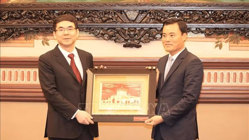 Заместитель председателя Народного комитета г. Хошимина Буй Суан Кыонг (справа) дарит сувенир Заместителю мэра Гуанчжоу Лай Чжихуну. Фото: ВИА