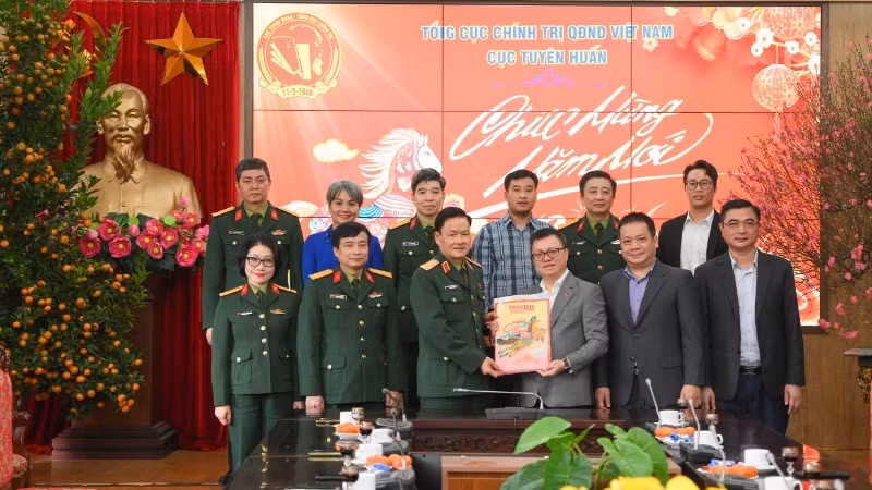 Главный редактор Ле Куок Минь вручает новогодние номера газеты кадровым работникам и военнослужащим Управления пропаганды и просвещения Главного политического управления ВНА.