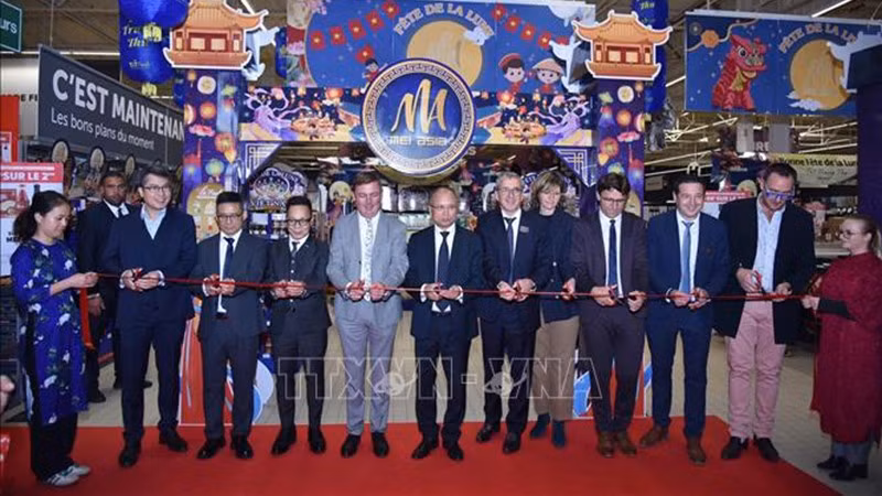 Посол Динь Тоан Тханг, руководители французских местностей и гости разрезают ленту в знак открытия Недели вьетнамских товаров в супермаркете Carrefour. Фото: ВИА