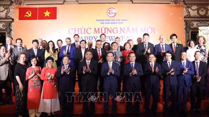 Член Политбюро, Секретарь Партокома г. Хошимина Чан Лыу Куанг и руководители города фотографируются на память с делегатами на встрече. Фото: ВИА