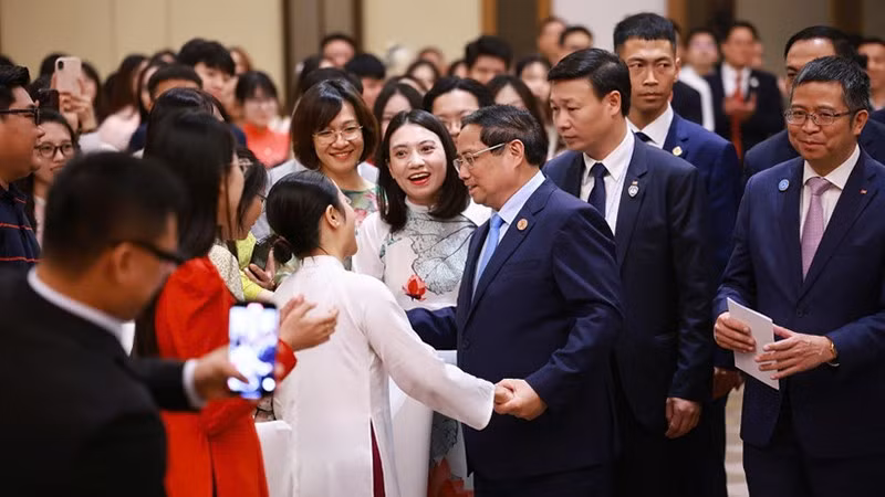 Премьер-министр Фам Минь Тьинь и представители сообщества вьетнамцев в Китае. Фото: VGP