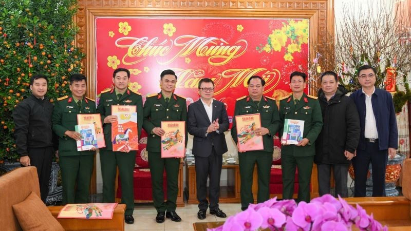 Товарищ Ле Куок Минь (в центре) вручает 325-й дивизии новогодние номера газеты.