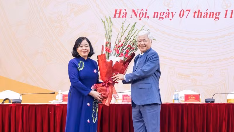 Постоянный замсекретаря Парткома НС, бывший Председатель ЦК ОФВ До Ван Тьиен вручает цветы с поздравлением товарищу Буй Тхи Минь Хоай.