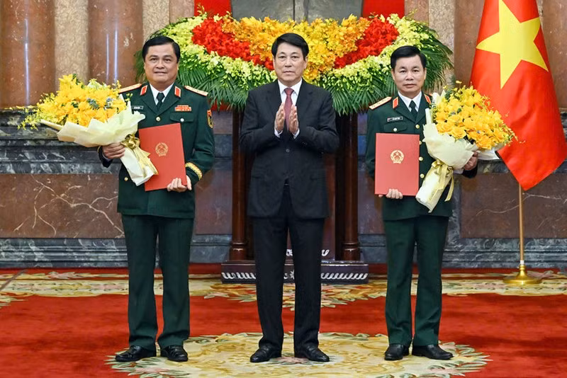 Президент Лыонг Кыонг вручает решение о присвоении воинского звания товарищам До Суан Тунгу и До Ван Баню. Фото: Тхюи Нгуен