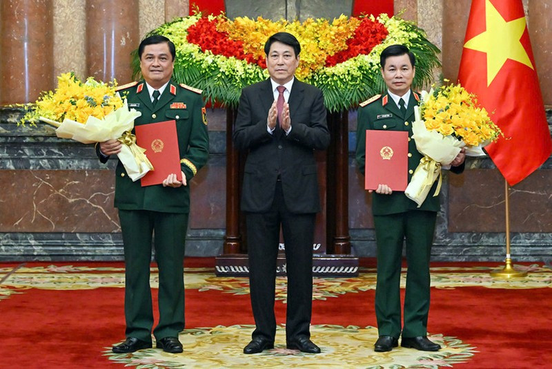 Президент Лыонг Кыонг вручает решение о присвоении воинского звания товарищам До Суан Тунгу и До Ван Баню. Фото: Тхюи Нгуен