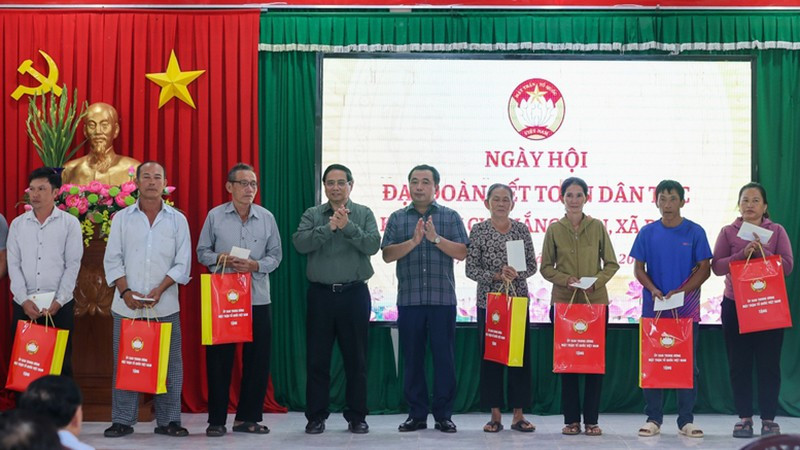 Премьер-министр Фам Минь Тьинь вручает подарки семьям жилого района Тхангкиен общины Деги. Фото: VGP