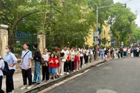 Утром 27 апреля сестры Линь Тьи и Ан Ньиен (в красных футболках с желтыми звездами) выстроились в очередь, терпеливо ожидая своей возможности ознакомиться с продукцией газеты «Нянзан».