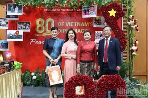 Посол Вьетнама в Лаоса Нгуен Минь Там вместе с супругой и международными друзьями у вьетнамского стенда. (Фото: Зюи Тоан)