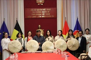 Г-н До Фыок Чунг, заместитель директора Департамента культуры и спорта города Хошимина, вручает традиционные шляпы «нон куай тхао» Клубу наследия вьетнамского «аозая» в Королевстве Бельгия. (Фото: ВИА)