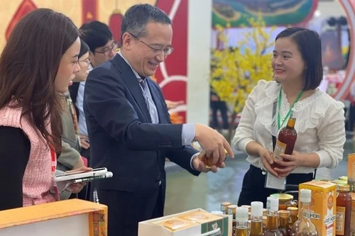 Главный представитель ханойского офиса JETRO Одзаса Харухико (в центре) посещает один из стендов на первой ярмарке «Славная весна» 6 февраля. Фото: ВИА