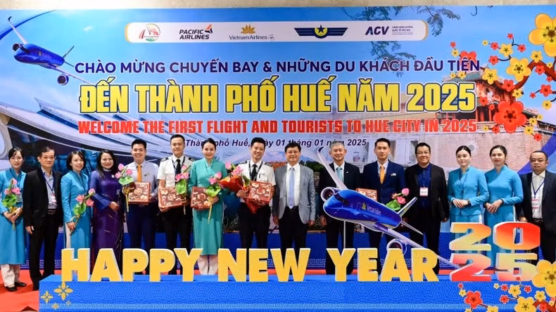 Руководители города Хюэ и туристической индустрии фотографируются с группой пассажиров, капитаном и бортпроводниками воздушного судна.