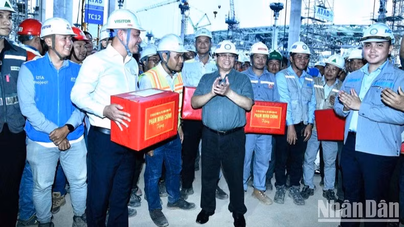 Премьер-министр Фам Минь Тьинь вручает подарки в знак поощрения строительного подразделения.