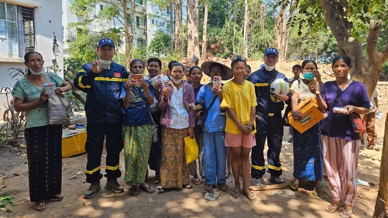 Люди получают продовольственную помощь от офицеров и сотрудников Министерства общественной безопасности Вьетнама.