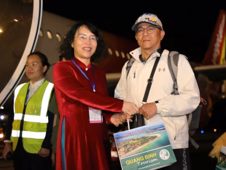 Директор Департамента культуры, спорта и туризма провинции Куангбинь Нгуен Тхи Бить Тхюи вручает пассажирам подарки.
