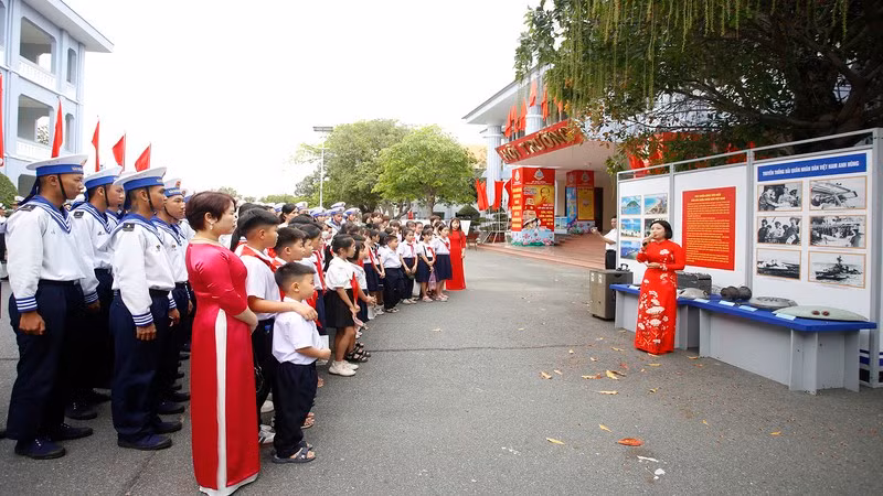 Офицеры ВМС, солдаты и школьники посещают выставку.