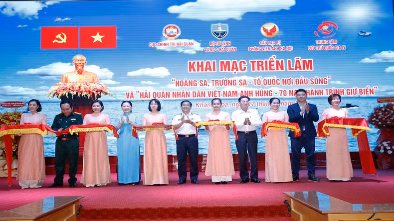 Делегаты перерезают ленточку в знак открытия выставки.