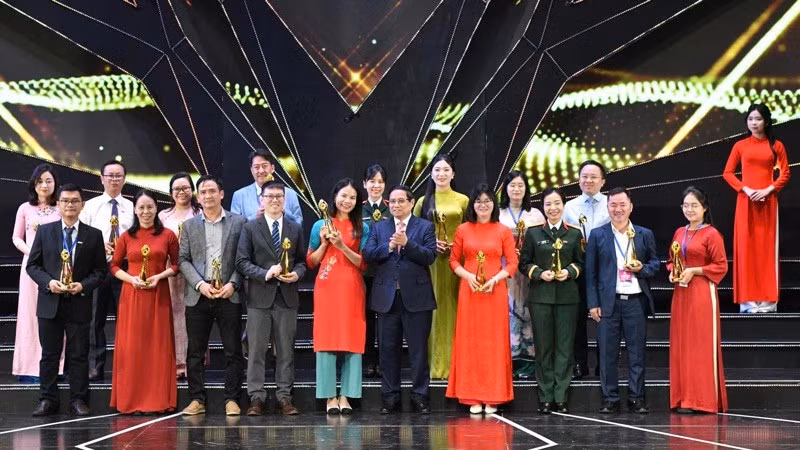 Премьер-министр Фам Минь Тьинь награждает авторов, завоевавших золотые призы. Фото: Тхань Жанг