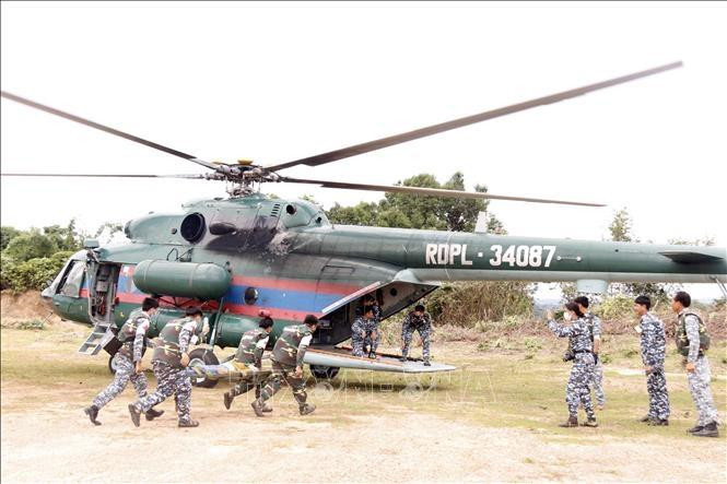 Военнослужащие заносят жителя в вертолет в рамках учений. Фото: VNA