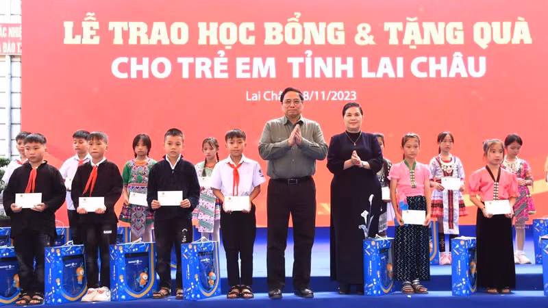 Премьер-министр Фам Минь Тьинь вручает подарки и стипендии ученикам. Фото: Чан Хай