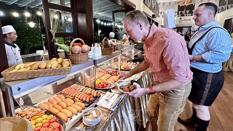 Международные посетители наслаждаются немецкими блюдами. Фото: ВИА
