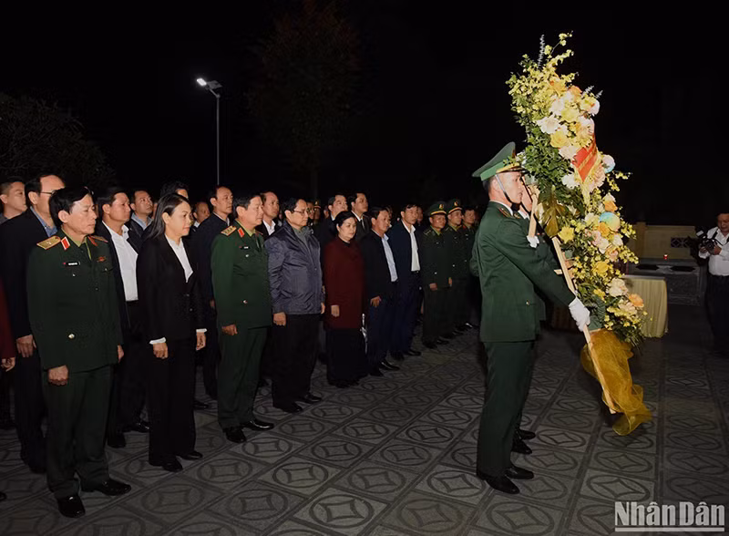 Премьер-министр воскуряет благовония и возлагает цветы к мемориальной стеле с именами мучеников и павших героев. Фото: Чан Хай