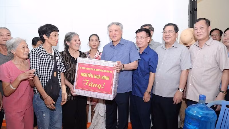 Постоянный вице-премьер Нгуен Хоа Бинь вручает подарки жителям города Намдинь. 