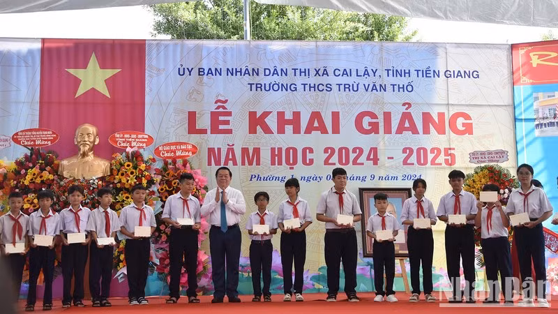 Заведующий Отделом ЦК КПВ по пропаганде и политическому воспитанию Нгуен Чонг Нгиа вручает учащимся стипендии.