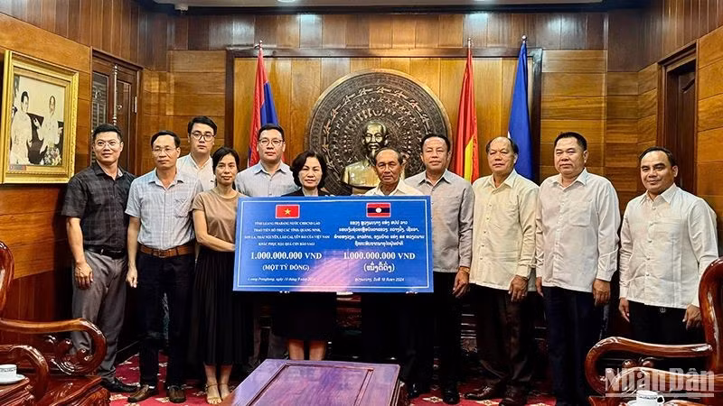 Делегация провинции Луангпрабанг передает средства в поддержку вьетнамским провинция.