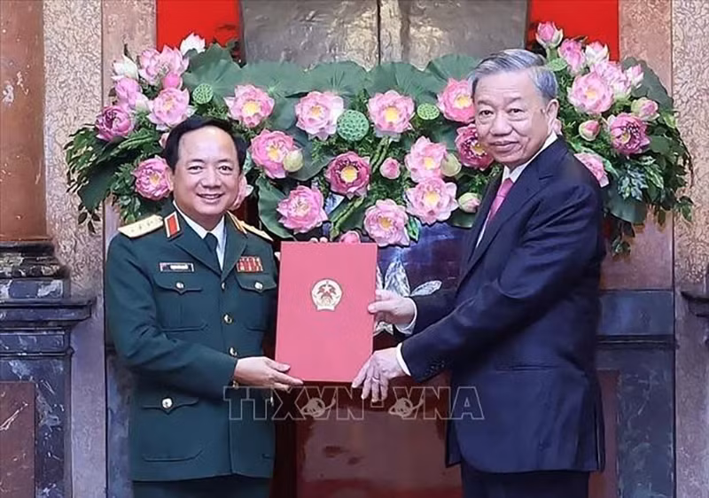 Президент То Лам вручает решение генерал-полковнику Чинь Ван Куету. Фото: ВИА