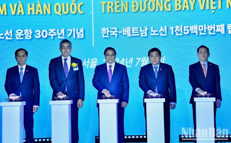 Премьер-министр Фам Минь Тьинь и делегаты нажимают кнопки в знак празднования 30-летия открытия прямого авиарейса между Вьетнамом и Южной Кореей. Фото: Тхань Жанг