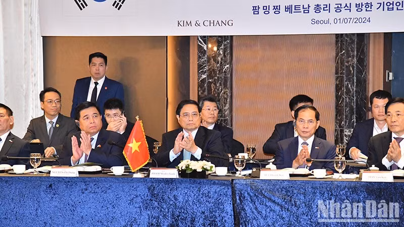 Премьер-министр Фам Минь Тьинь принимает участие в беседе.