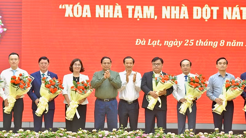 Премьер-министр Фам Минь Тьинь вручает цветы представителям предприятий, оказавших поддержку программе. Фото: Тхань Жанг