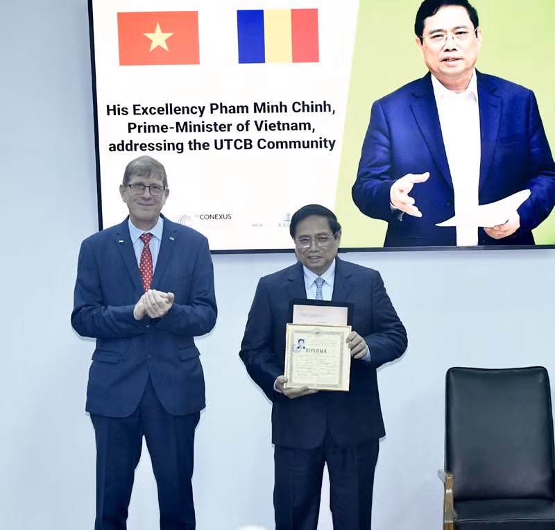 Руководитель Технического строительного университета Бухареста вручает Премьер-министру Фам Минь Тьиню копию его предыдущих академических достижений. Фото: Тхань Жанг