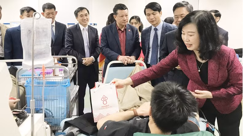 Товарищ Дао Хонг Лан навещает доноров крови и вручает им подарки.