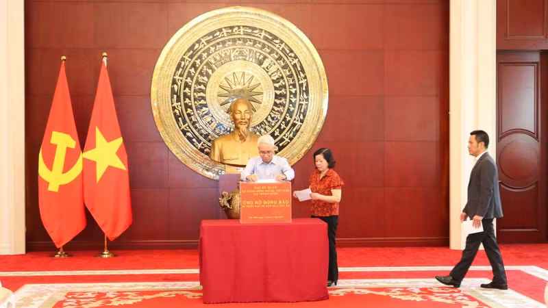 Посол Вьетнама в Китае Фам Шао Май с супругой делает пожертвования на поддержку соотечественников.