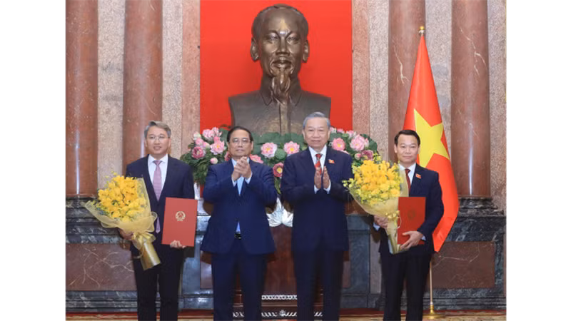 Генеральный секретарь ЦК КПВ, Президент То Лам вручает решения, Премьер-министр Фам Минь Тьинь вручает цветы Министру природных ресурсов и охраны окружающей среды и Министру юстиции. Фото: ВИА
