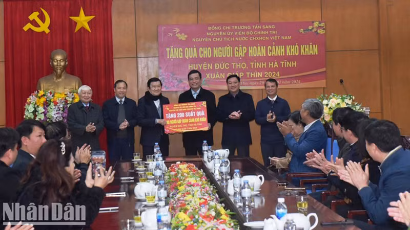 Бывший Президент Чыонг Тан Шанг символически вручает семьям в уезде Дыктхо (провинция Хатинь) 200 новогодних подарков.