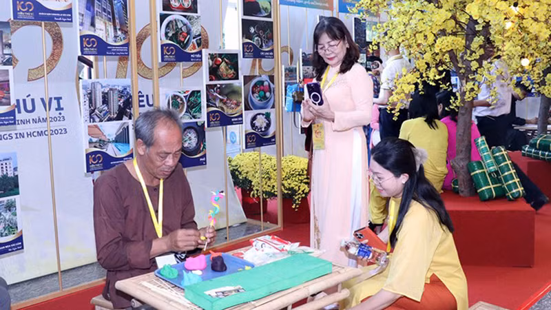 Делегаты наблюдают, как ремесленники делают традиционные детские игрушки «тохе». Фото: Суан Кху