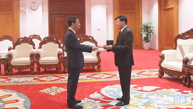 Посол Нгуен Минь Там вручает верительные грамоты Генеральному секретарю ЦК НРПЛ, Президенту Лаоса Тхонглуну Сисулиту. Фото: Чинь Зунг