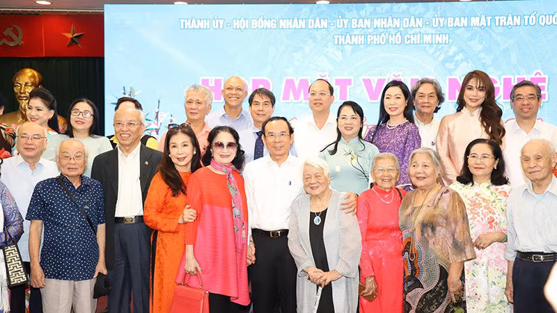 Руководители г. Хошимина фотографируются с писателями и художниками на встрече. Фото: Т. Тунг