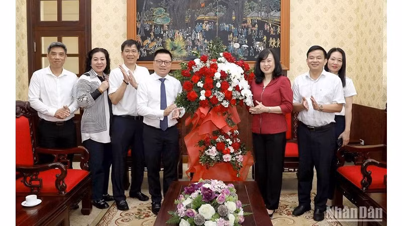 Министр здравоохранения Дао Хонг Лан вручает цветы члену ЦК КПВ, Главному редактору газеты «Нянзан», Заведующему Отделом ЦК КПВ по пропаганде и политическому воспитанию, Председателю Союза журналистов Вьетнама Ле Куок Миню. Фото: Данг Кхоа