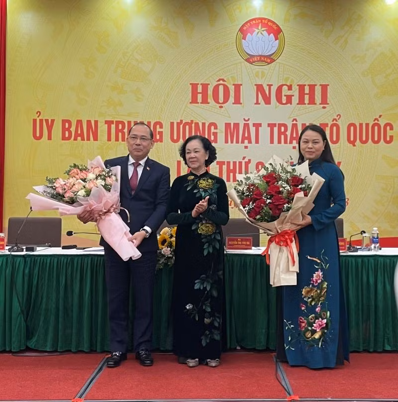 Товарищ Чыонг Тхи Май вручает цветы товарищам Нгуен Тхи Тху Ха и Хоанг Конг Тхюи.