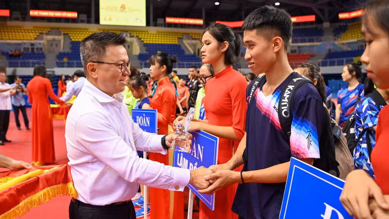 Главный редактор газеты «Нянзан» Ле Куок Минь вручает командам памятные медали. Фото: Зюи Линь