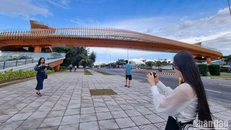 Первые молодые люди делают фотографии возле моста. Фото: Ань Дао