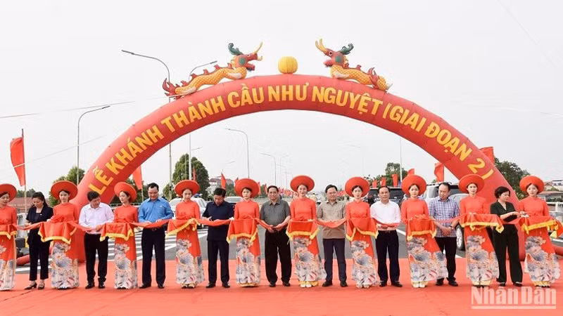 Премьер-министр Фам Минь Тьинь и делегаты разрезают ленточку в знак открытия моста Ньынгует (2-й этап). Фото: Чан Хай