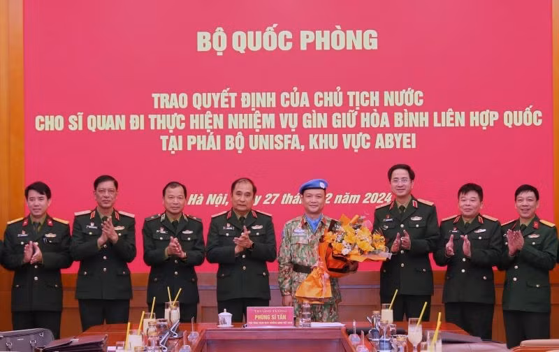 Майора Хоанг Динь Конга поздравляют генерал-полковник Фунг Ши Тан и представители ведомств и подразделений.