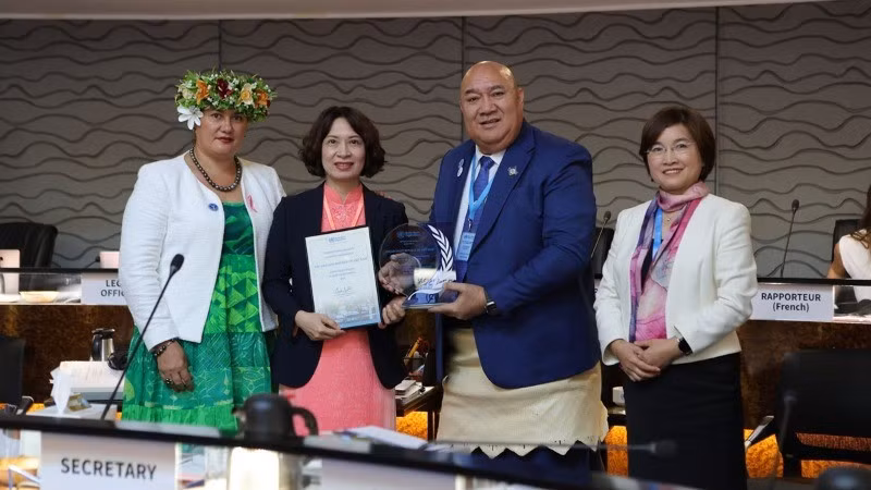 Замминистра Нгуен Тхи Лиен Хыонг (вторая слева) получает сертификат и мемориальную доску.