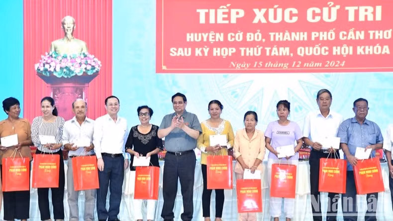 Премьер-министр Фам Минь Тьинь вручает подарки выдающимся семьям инвалидов войны, павших бойцов и бедным католическим семьям в уезде Кодо. Фото: Тхань Жанг