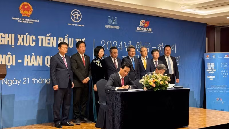Г-н Нгуен Ань Зыонг, директор Ханойского центра содействия инвестициям, торговле и туризму, подписывает соглашение о сотрудничестве с южнокорейскими партнерами.